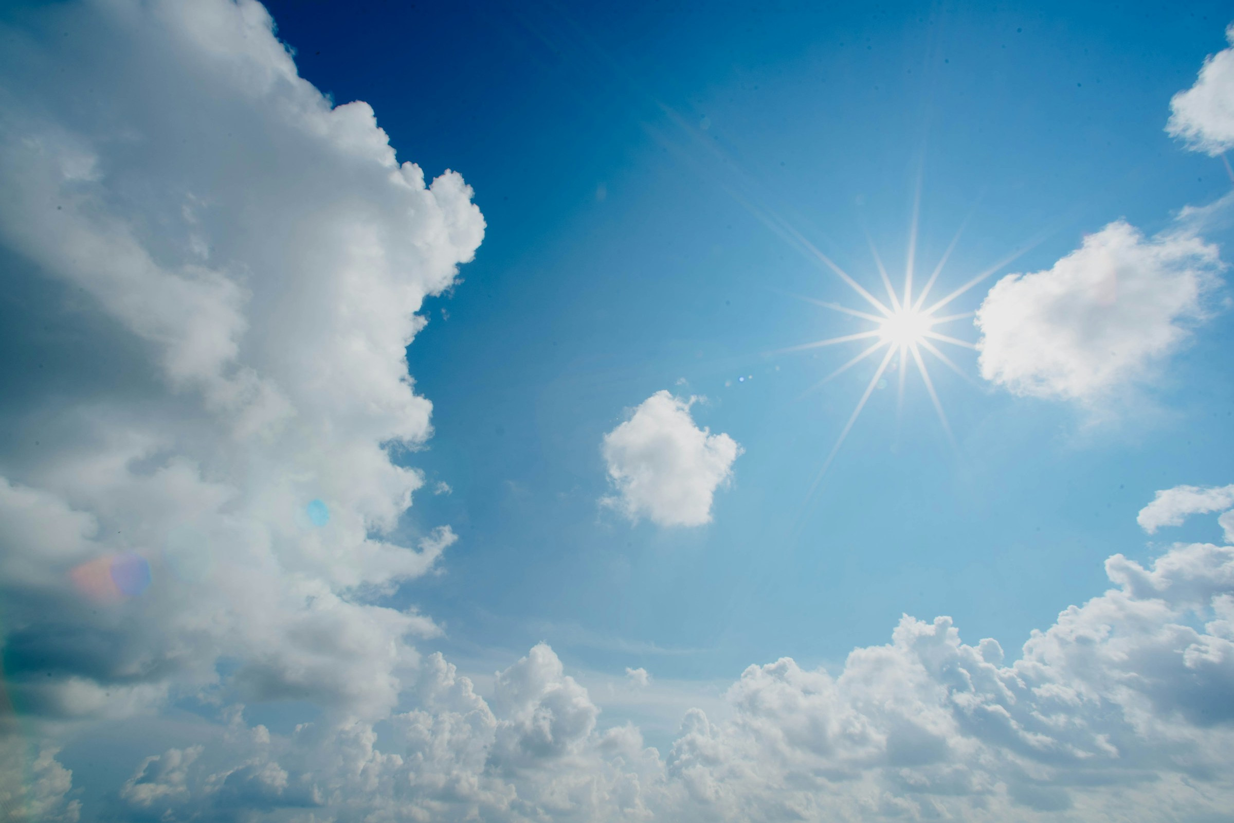 blauer Himmel mit Wolken und Sonne